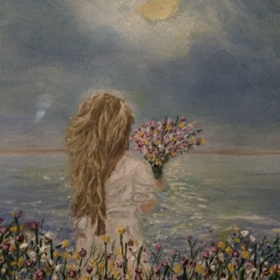 Girl with flowers looking at the ocean