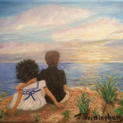 Boy and girl watching sunset over ocean