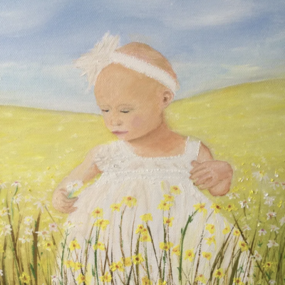 infant girl in a field holding a flower